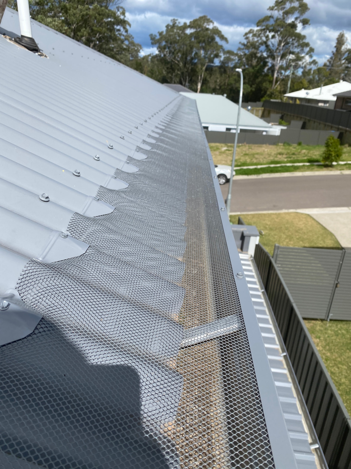 Powder-coated aluminium leaf mesh gutter guard installed along a roof edge